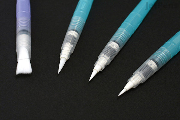Four Kuretake Water Brush pens with different tip shapes and sizes are arranged diagonally on a black background. The pens have translucent blue and white bodies with white brush or nib tips.