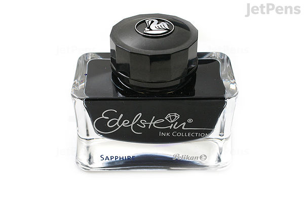 A 50 ml bottle of Pelikan Edelstein Sapphire fountain pen ink. The bottle is clear glass with a black cap and a label reading "Edelstein Ink Collection" and "Sapphire." The ink inside is a deep blue color.