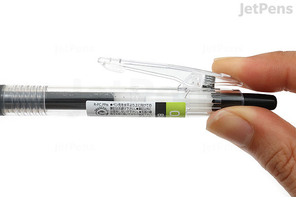 A hand holding a Pilot Juice Gel Pen with a 0.38 mm black tip, featuring a clear barrel and a black cap.