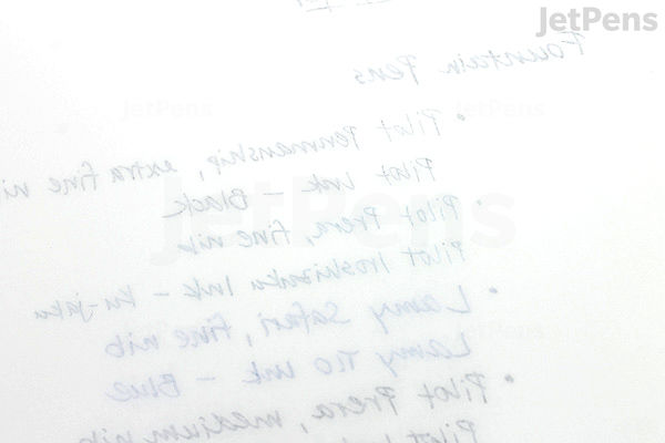 Close-up image of a page from a Tomoe River 52 gsm Kanso Notebook in B5 size with white paper, showing faint handwritten text in blue ink. The paper appears smooth and thin, highlighting the notebook's high-quality, lightweight design.
