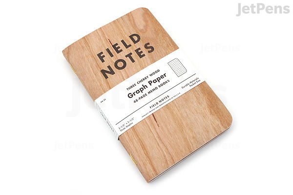 A pack of three Field Notes memo books with cherry wood-patterned covers. Each book measures 3.5 by 5.5 inches and contains 48 pages of graph paper. The pack is wrapped with a white paper band labeled "Field Notes" and product details.