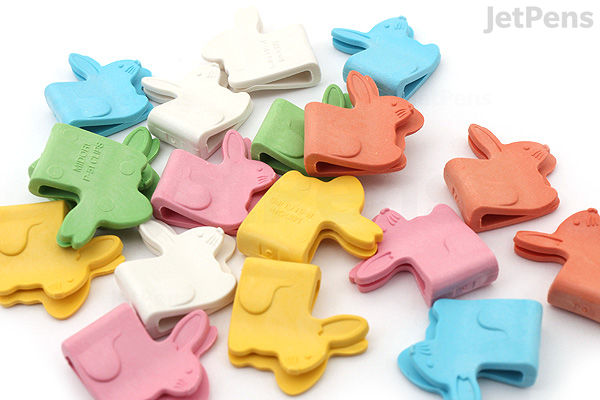 Colorful paper clips shaped like birds, scattered on a white surface. The clips come in pastel shades of blue, pink, yellow, green, white, and orange.
