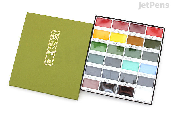 A 24-color Kuretake Gansai Tambi watercolor palette set, with the lid open to show vibrant rectangular pans of paint arranged in four rows inside a green box.