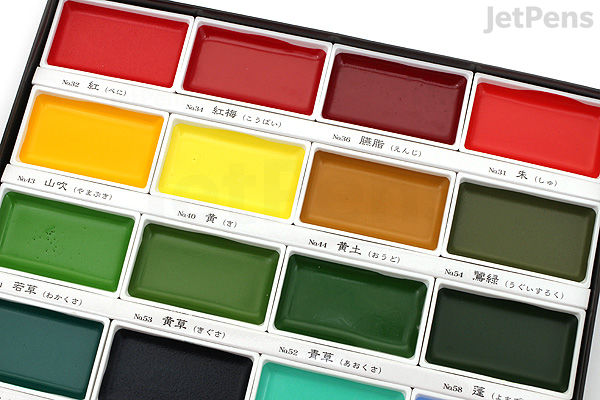 A close-up view of a Kuretake Gansai Tambi Watercolor Palette featuring 24 vibrant colors arranged in rows. The visible section shows bright reds, yellows, greens, and dark shades in rectangular pans with Japanese and English labels beneath each color.