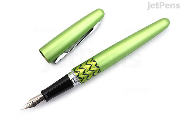 A Pilot Metropolitan Retro Pop fountain pen in green marble finish with the cap removed, showing the fine nib and a black grip section with a yellow and black zigzag pattern near the nib.