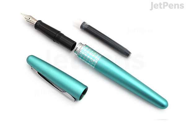 A turquoise Pilot Metropolitan Retro Pop fountain pen with fine nib, featuring a pattern of small dots on the barrel. The pen is shown uncapped with the cap lying beside it.
