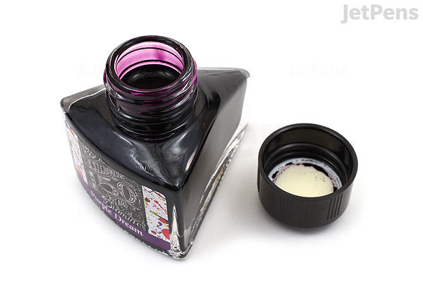 A 40 ml square glass bottle of Diamine Purple Dream Ink, part of the 150th Anniversary collection, with the cap removed and placed beside it, showing the vibrant purple ink inside.