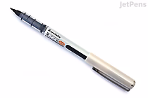 A Kuretake Fudegokochi brush pen with an extra fine black tip, featuring a transparent grip section and a silver cap.