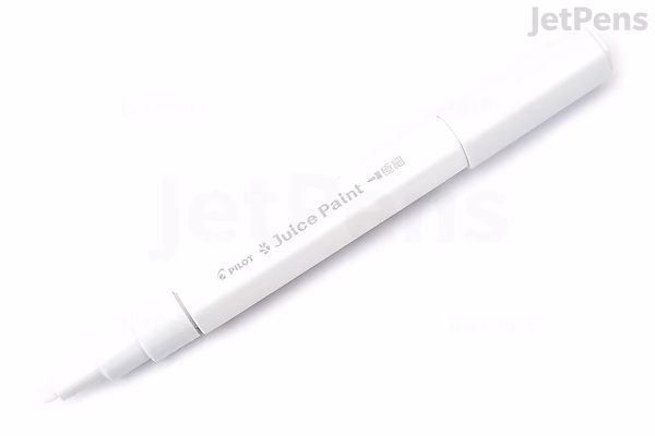 A white Pilot Juice Paint Marker with an extra fine tip, shown uncapped and lying diagonally on a white background. The pen has black text indicating the brand and type.