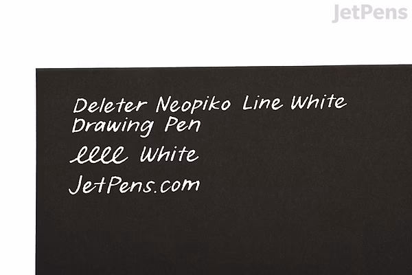 A close-up image of a black surface with white handwritten text that reads: "Deleter Neopiko Line White Drawing Pen 0.5 mm White JetPens.com".