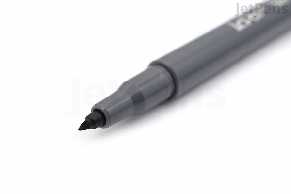 Close-up image of a Marvy Le Pen Flex Brush Pen with a dark grey barrel and a flexible brush tip, shown on a white background.