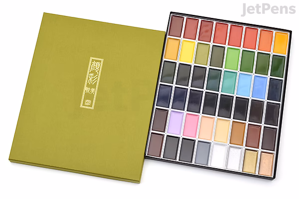 A 48-color Kuretake Gansai Tambi watercolor palette with a green cover, showing a wide range of vibrant and pastel paint colors arranged in six rows inside a black tray.
