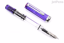 A transparent purple fountain pen with a fine nib, shown uncapped with the cap placed beside it. The pen body is clear, revealing the internal ink reservoir and mechanism.