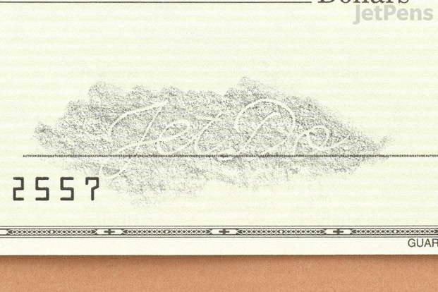 Pencil rubbed over the signature line of a check, clearly showing the indentations of a signature.