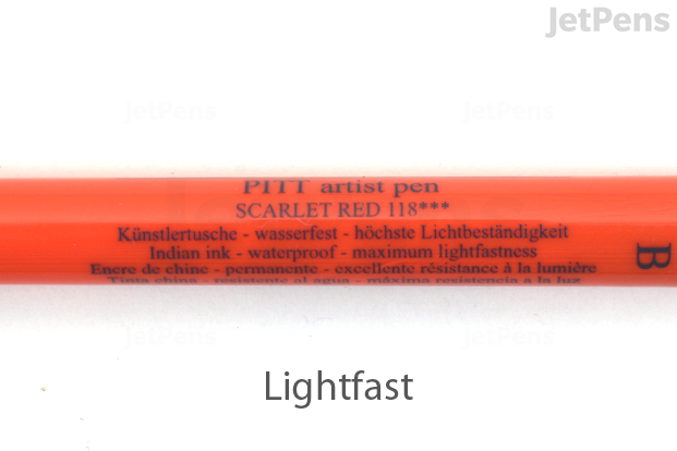 A closeup of the barrel of a Scarlet Red Faber-Castell PITT Artist Pen, showing three asterisks indicating maximum lightfastness.