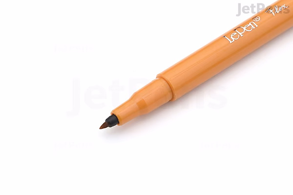 Close-up of an ochre-colored Marvy Le Pen Flex Brush Pen with its black flexible brush tip visible.