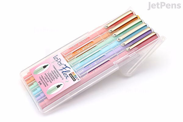 A clear plastic case containing six Marvy Le Pen Flex brush pens in pastel colors, arranged side by side. The pens have gold-colored caps and clips, and the packaging label displays the brand and product details.
