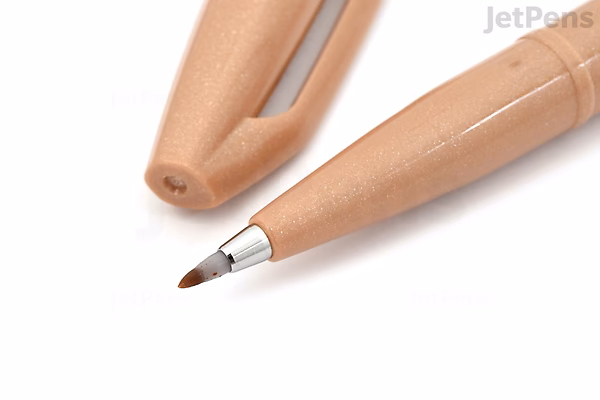 Close-up image of a Pentel Fude Touch Brush Sign Pen in pale brown color, showing the pen tip and the cap placed beside it on a white background.
