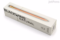 Box of Blackwing Natural pencils with extra firm lead, containing 12 pencils. The packaging is white with black text and a clear window showing one pencil inside.