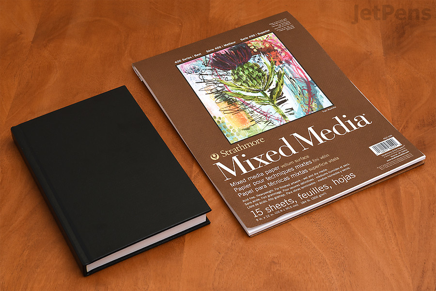 Two sketchbooks on a table.