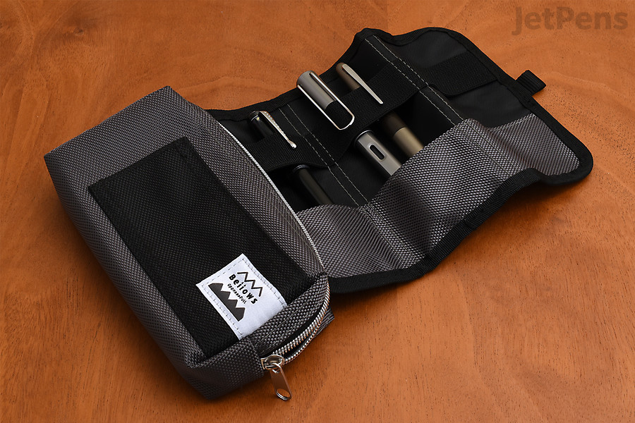 A case opened on a table, containing some pens.