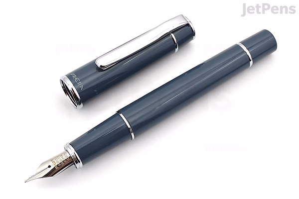 A Pilot Prera fountain pen in slate gray with a fine nib, shown uncapped with the cap placed beside the pen. The pen has a sleek, smooth body with silver accents.