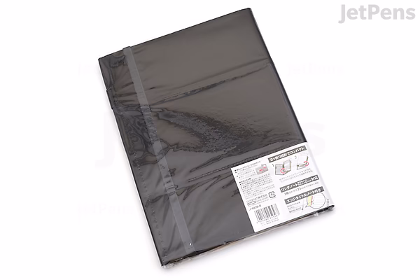 A black KOKUYO Systemic Cover A5 notebook with a fabric cover and ring binding, featuring 6 mm ruled pages, shown in its original plastic packaging.