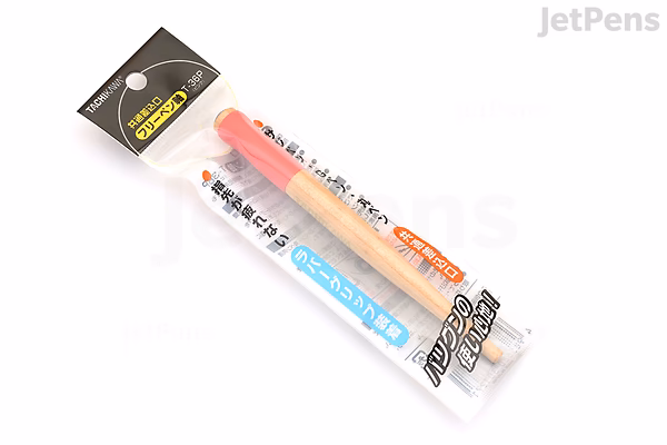 A Tachikawa T-36 nib holder with a pink grip, packaged in clear plastic with a black and yellow label at the top. The nib holder is visible inside the packaging.