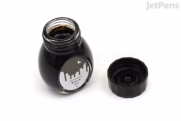 Open black ink bottle labeled "Colorverse Permanent Black Ink - Office - 30 ml," with the black screw cap placed beside it on a white background.
