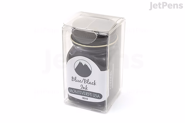 A 30 ml bottle of Monteverde Black Ash Ink inside a clear plastic display case. The bottle is dark with a white label featuring a mountain logo and the text "Black Ash."