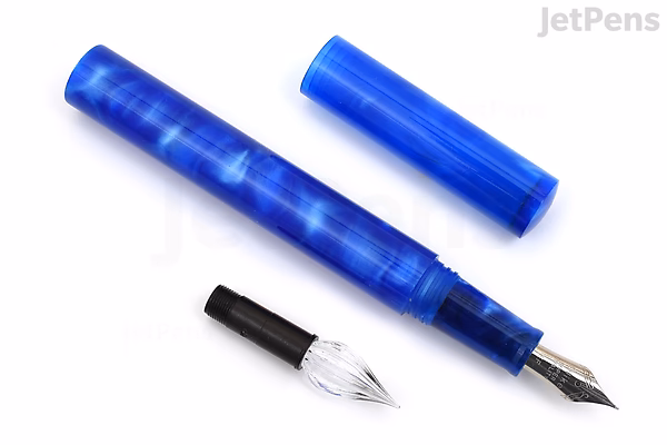 A Majohn N6 fountain pen in iris blue swirl finish, shown uncapped with its extra fine fude nib attached and a separate glass dip nib beside it. The pen has a glossy, marbled blue body and cap.
