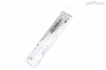 A Kuretake Karappo empty brush pen with a bristle tip, packaged in clear plastic. The pen is white with black accents and comes with two ink cartridges. The packaging displays the brand name and product details.