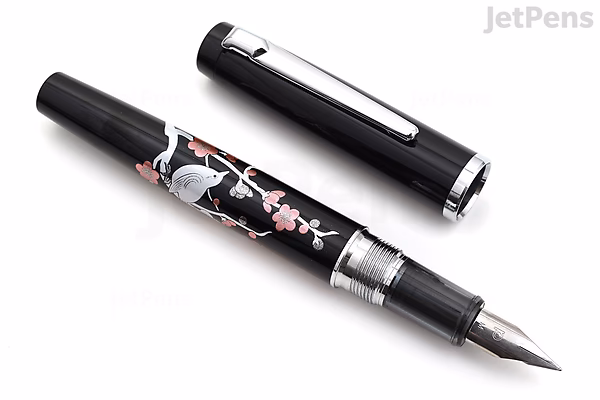 Black fountain pen with silver clip and fine nib, decorated with intricate pink and white brush warbler bird and plum tree branch design, displayed with cap removed and placed beside it.
