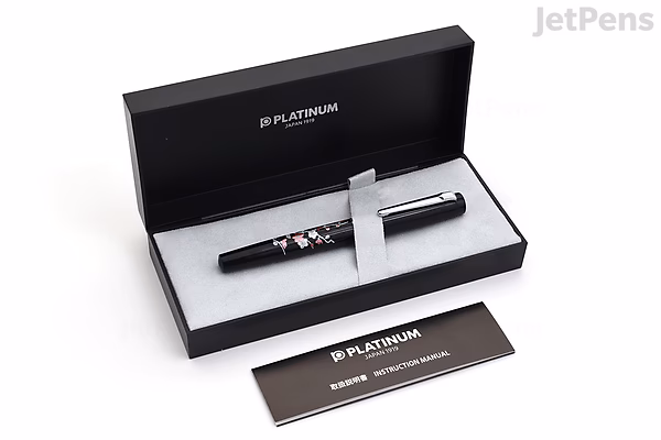 Platinum Procyon Maki-e Fountain Pen with Brush Warbler on Plum Tree design, fine nib, displayed in an open black presentation box with a matching black booklet beside it. Limited edition pen with intricate artwork.