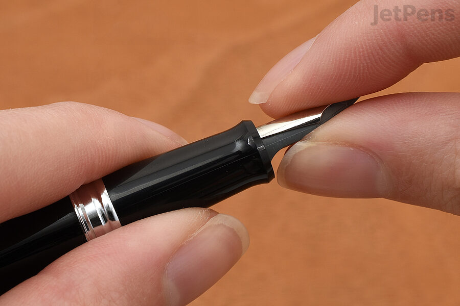 1. Start with a clean pen. Using your fingers or a piece of soft, grippy material like rubber shelf liner, firmly grasp the top of the nib and the bottom of the feed. Use your other hand to hold the grip section.