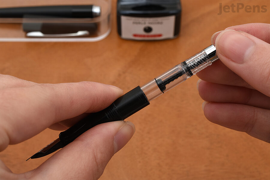 1. Insert the converter into the grip section of the pen. Twist the end knob to fully extend the piston.