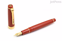 Image of a Sailor Pro Gear Slim fountain pen in Autumn Sky color. The pen has a deep reddish-brown barrel with gold accents, a gold nib, and the cap is shown removed and placed beside the pen. The nib is marked 14k Extra Fine.