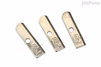 Three Blackwing One-Step Sharpener replacement blades arranged side by side on a white background. Each blade is metallic with a hole near one end and has "GEM" engraved on it.