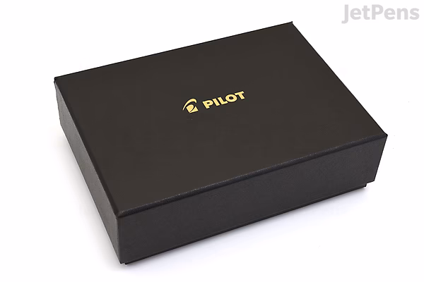 Black rectangular box with the gold Pilot logo centered on the lid, containing a Pilot Custom 743 fountain pen.
