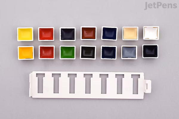 Kuretake Gansai Tambi Mini Watercolor Palette with 14 small rectangular pans of vibrant watercolor paints arranged in two rows above a white plastic palette tray.