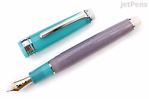 A Sailor Pro Gear Slim fountain pen with a turquoise cap and a lavender barrel featuring subtle mermaid scale patterns. The pen has a silver clip and a 14k fine nib. The cap is removed and placed beside the pen.