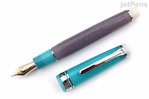 Sailor Pro Gear fountain pen with cap removed, showing 21k medium fine nib. The pen body is teal with silver accents, and the cap is a textured purple. Limited edition "Follow the Mermaid" design.