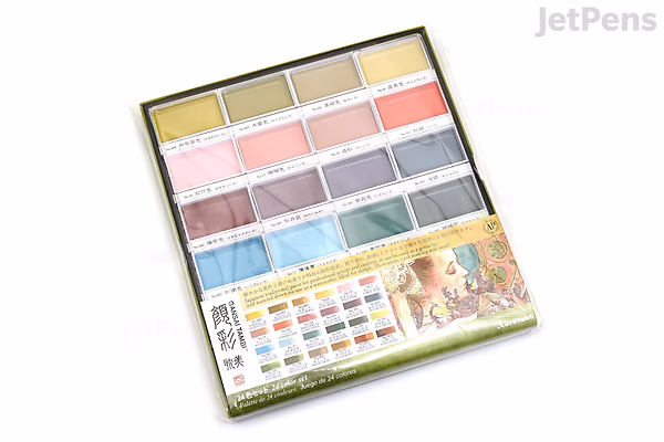 A Kuretake Gansai Tambi Watercolor Palette featuring 24 rectangular pans of vibrant colors arranged in three rows within a white plastic case. The palette packaging displays color swatches and Japanese text along the bottom edge.