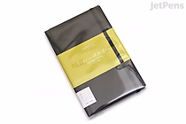 A KOKUYO PERPANEP Premium Notebook in black with a yellow paper band around it, labeled "Tsuru Tsuru" and featuring 4 mm graph paper inside. The notebook is wrapped in clear plastic.