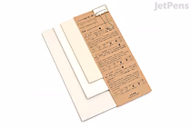 Three sheets of Yamamoto Washi paper in varying shades of off-white and beige, arranged in a slightly overlapping fan shape, with a tan-colored label featuring Japanese text and product information placed on top.