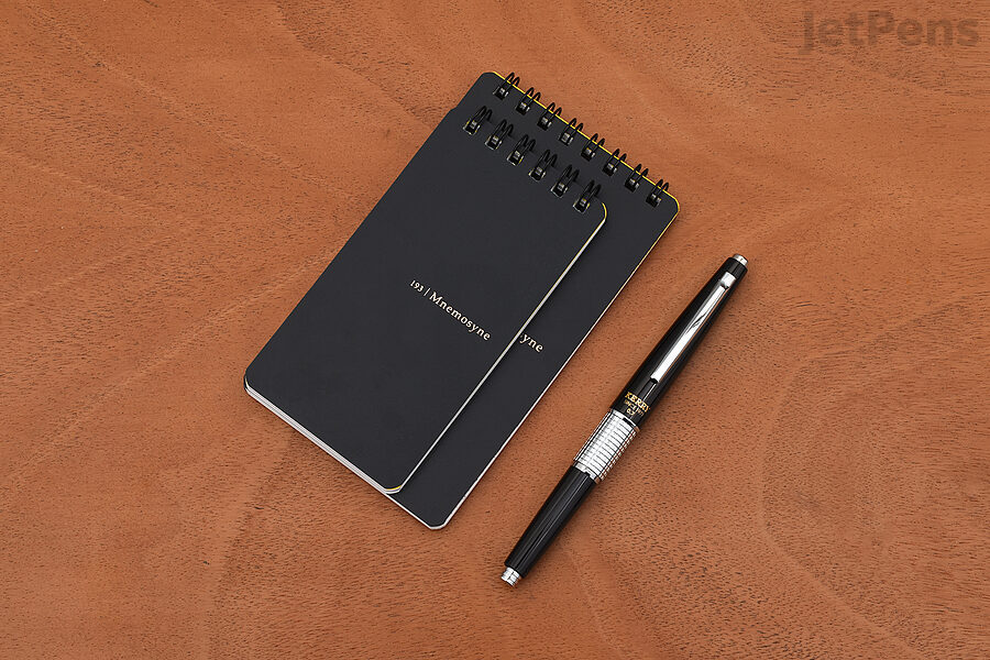 The Maruman Mnemosyne Twin-Ring Notepad features a sleek, protective black cover and smooth, fountain pen friendly paper.