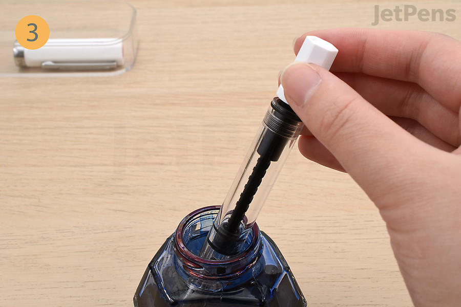 Dip the fountain pen in an ink bottle.