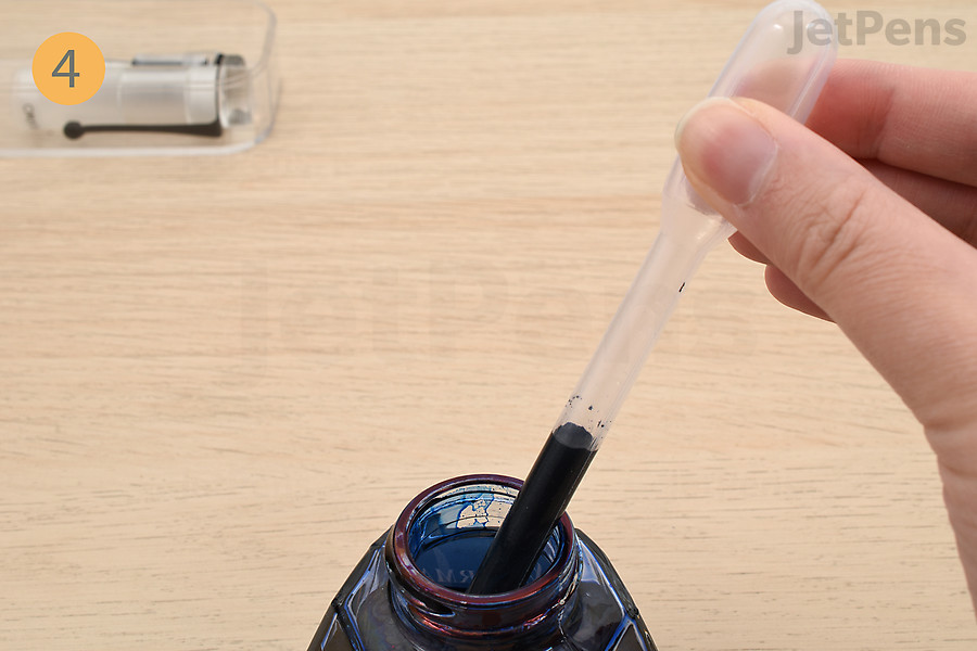 Fill an eyedropper, syringe, or pipette from an ink bottle.