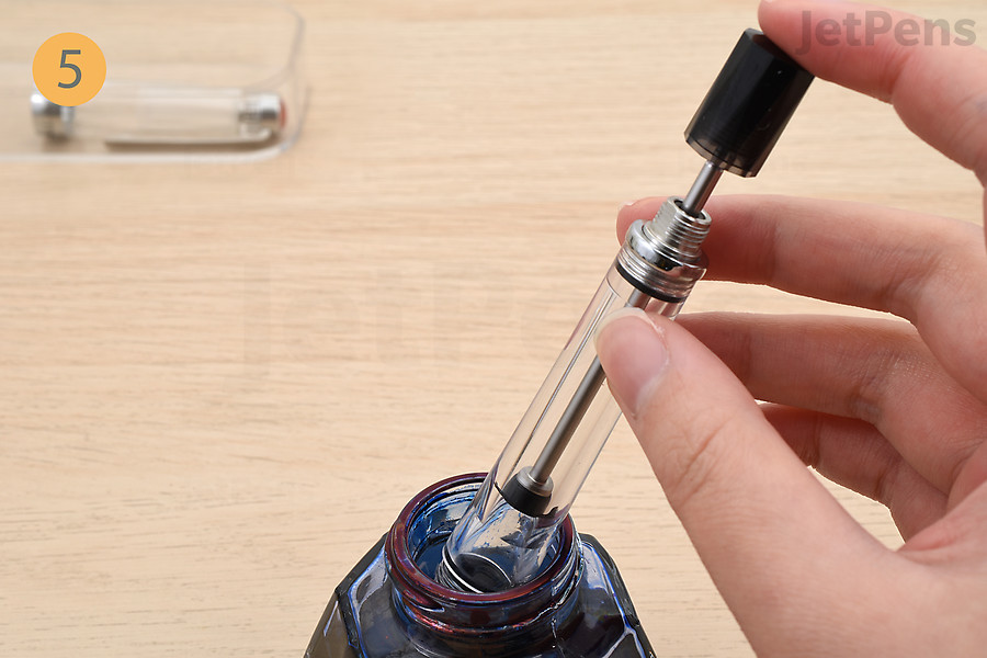 Dip the fountain pen in an ink bottle.
