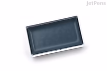 A rectangular watercolor paint pan filled with grayish blue paint, labeled as Kuretake Gansai Tambi Watercolor No. 601.